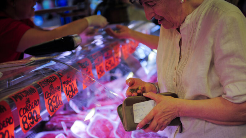 BARCELONA, ESPAÑA - 22 DE JUNIO: Un cliente comprueba su cambio después de comprar carne con billetes en euros en un puesto de carnicería en el mercado de productos frescos 'La Boqueria' el 22 de junio de 2011 en Barcelona, ​​España. (Foto de David Ramos/Getty Images)
