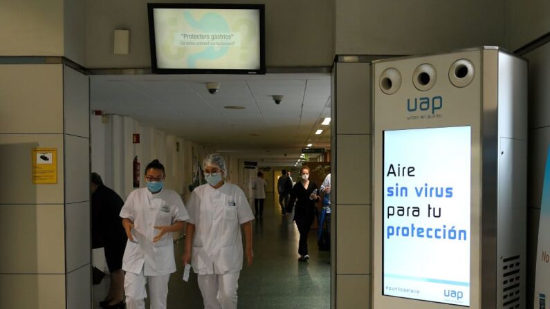 Trabajadores sanitarios pasan junto a un purificador de aire cuya pantalla en el Hospital Clinic de Barcelona el 14 de mayo de 2020, durante un cierre nacional para evitar la propagación de la enfermedad COVID-19. (LLUIS GENE/AFP vía Getty Images)