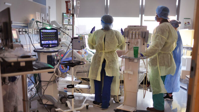 La terapeuta respiratoria Annette Johnson (izquierda) ayuda a tratar a un paciente con COVID-19 en la UCI del Centro Médico de la Universidad Rush el 31 de enero de 2022 en Chicago, Illinois. (Scott Olson/Getty Images)