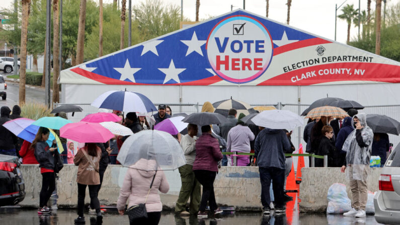 La gente hace cola bajo la lluvia para votar en una tienda en el aparcamiento de un centro comercial en Las Vegas, Nevada, el 8 de noviembre de 2022. Tras meses de campaña de los candidatos, los estadounidenses votan en las elecciones de medio mandato para decidir reñidas contiendas en todo el país. (Ethan Miller/Getty Images)