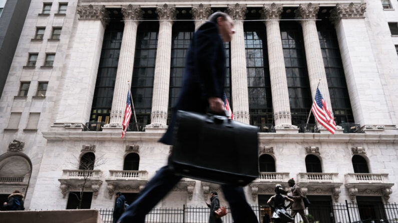 Varias personas pasan por delante de la Bolsa de Nueva York (NYSE) el 16 de marzo de 2023 en Nueva York. Las acciones volvieron a caer en las operaciones de la mañana mientras los inversores siguen mostrando su preocupación por la estabilidad de los bancos mundiales.  (Spencer Platt/Getty Images)
