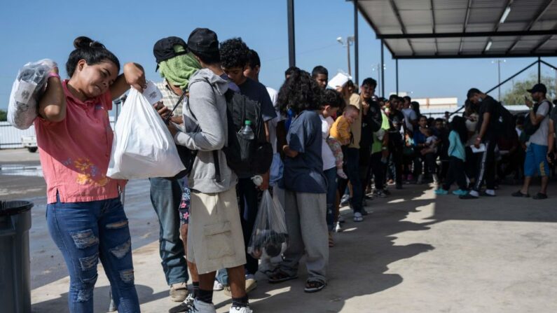 Inmigrantes hacen cola mientras esperan un autobús a Chicago en el complejo de la ONG Mission Border Hope para transportarlos fuera de Eagle Pass, Texas, el 26 de septiembre de 2023. (Andrew Caballero-Reynolds/AFP vía Getty Images)