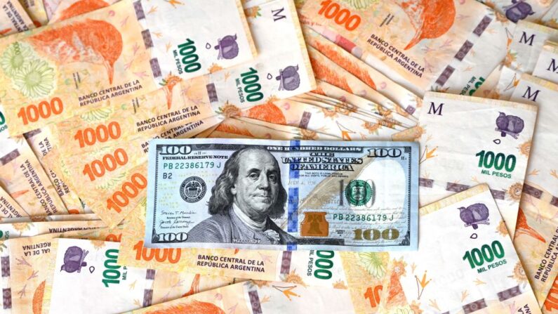 Esta ilustración muestra un billete de 100 dólares estadounidenses sobre pesos argentinos, en Buenos Aires (Argentina), el 10 de octubre de 2023. (Luis Robayo/AFP vía Getty Images)