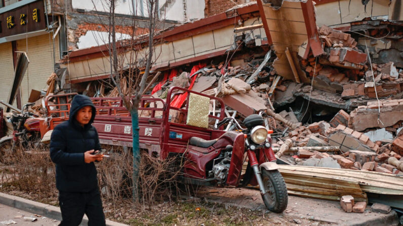 Un hombre pasa junto a un edificio derrumbado tras un terremoto en Dahejia, condado de Jishishan, en la provincia noroccidental china de Gansu, el 19 de diciembre de 2023. (Pedro Pardo/AFP vía Getty Images)