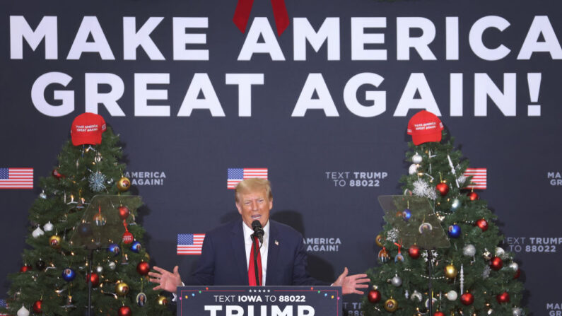 El candidato presidencial republicano y expresidente de EE. UU. Donald Trump habla con un invitado en un acto de campaña en Waterloo, Iowa, el 19 de diciembre de 2023. (Scott Olson/Getty Images)