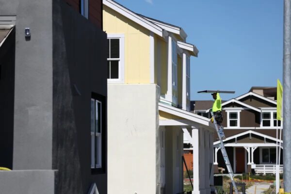 Un trabajador de la construcción lleva materiales mientras trabaja en una casa en construcción en una urbanización en Petaluma, California, el 23 de marzo del 2022. (Justin Sullivan/Getty Images)