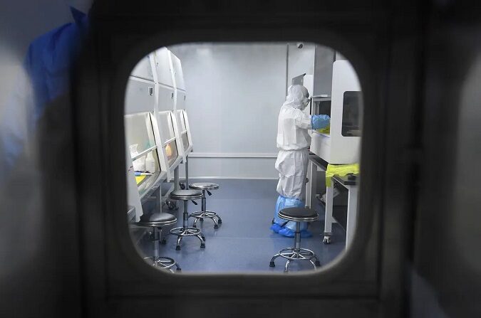 Un técnico del laboratorio BGI Group trabaja con muestras de personas que se someterán a la prueba del COVID-19 en el laboratorio "Fire Eye" de Wuhan, en la provincia china de Hubei, el 6 de febrero de 2020. (STR/AFP vía Getty Images)