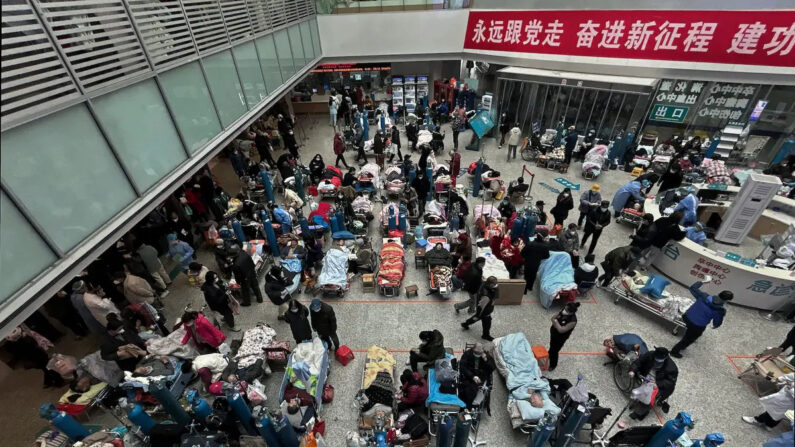 Los pacientes son atendidos por familiares y personal médico mientras se les ve en las camas instaladas en la zona del atrio de un concurrido hospital de Shanghái, China, el 13 de enero de 2023. (Kevin Frayer/Getty Images)