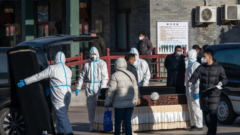 Trabajadores con equipo de protección manipulan un ataúd en la funeraria Dongjiao, supuestamente designada para ocuparse de las víctimas mortales del COVID-19, en Beijing, el 19 de diciembre de 2022. (Bloomberg vía Getty Images)