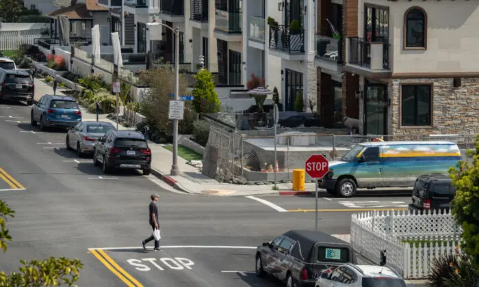Un hombre camina junto a unas viviendas en Huntington Beach, California, el 17 de marzo de 2023. (John Fredricks/The Epoch Times)