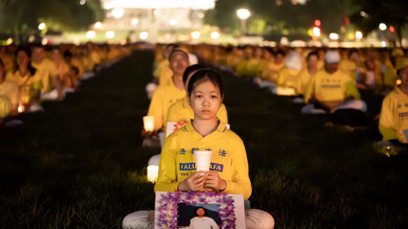 Practicantes de Falun Gong se reúnen en una vigilia con velas en memoria de los practicantes de Falun Gong fallecidos a causa de la persecución de esta disciplina espiritual durante 24 años por parte del Partido Comunista Chino, en el National Mall de Washington, el 20 de julio de 2023. (Madalina Vasiliu/The Epoch Times)