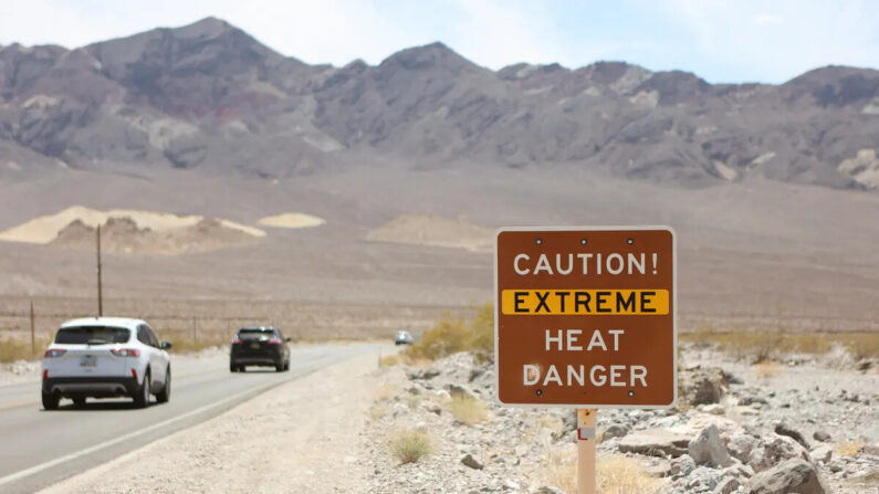 Una señal de advertencia de calor se muestra a lo largo de la carretera 190 de EE.UU. durante una ola de calor en el Parque Nacional del Valle de la Muerte en Death Valley, California, el 16 de julio de 2023. (Ronda Churchill/AFP vía Getty Images)