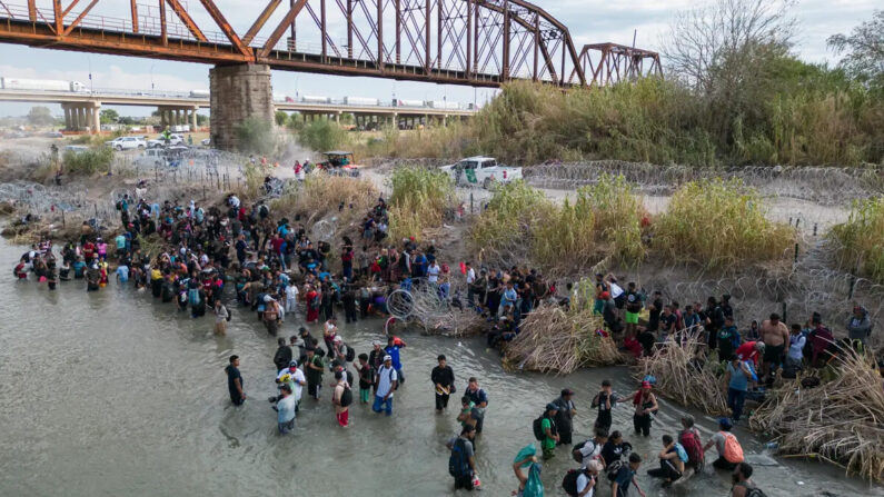 Migrantes esperan en el Río Grande una abertura en la barrera de alambre de púas, para cruzar a Estados Unidos, en Eagle Pass, Texas, el 25 de septiembre de 2023. (Andrew Caballero-Reynolds/AFP vía Getty Images)