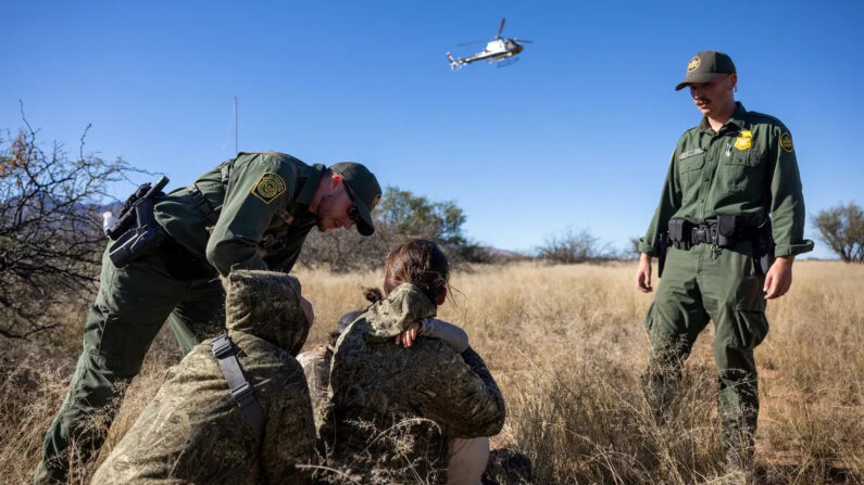 Agentes de la Patrulla Fronteriza y de Aduanas de EE.UU. detienen a una familia camuflada de México después de haber cruzado ilegalmente la frontera entre EE.UU. y México cerca de Naco, Arizona, el 4 de noviembre de 2022. (John Moore/Getty Images)