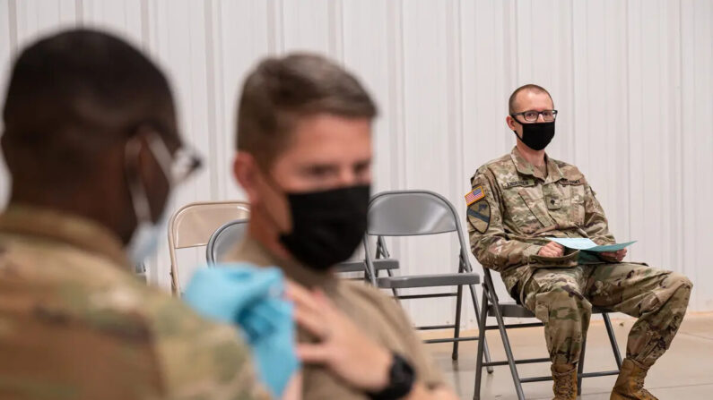Un soldado observa a otro recibir su vacuna COVID-19 de los Servicios Médicos Preventivos del Ejército en Fort Knox, Kentucky, el 9 de septiembre de 2021. (Jon Cherry/Getty Images)