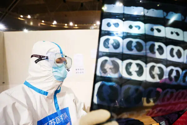 Un médico mira la tomografía computarizada de un paciente en un hospital temporal establecido para los pacientes de COVID-19 en un estadio deportivo en Wuhan, en la provincia central china de Hubei, el 5 de marzo de 2020. (STR/AFP vía Getty Images)