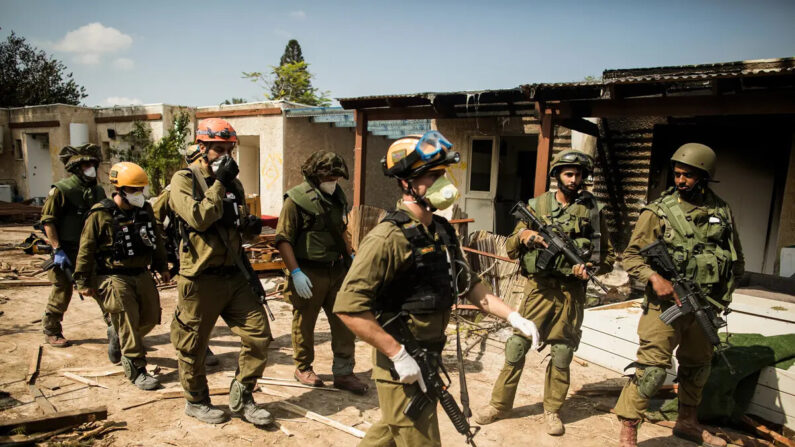 Soldados israelíes patrullan cerca de casas quemadas y destruidas tras un ataque terrorista de Hamás, cerca de la frontera con Gaza en Kfar Aza, Israel, el 10 de octubre de 2023. (Amir Levy/Getty Images)