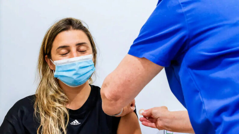 Una mujer cierra los ojos después de recibir una vacuna COVID-19 en Sydney Road Family Medical Practice en Balgowlah, en Sídney, Australia, el 10 de enero de 2022. (Jenny Evans/Getty Images)