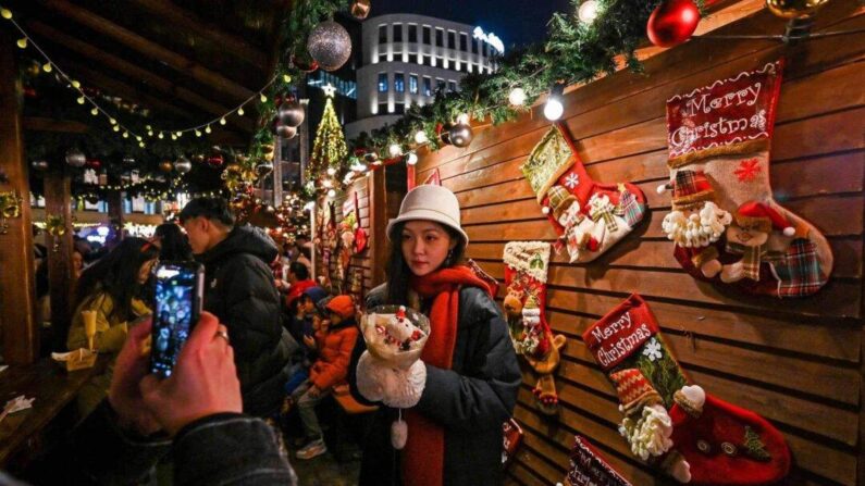 La gente visita un mercado de Navidad en el distrito de Huangpu en Shanghai el 23 de diciembre de 2023. (Hector Retamal / AFP via Getty Images)