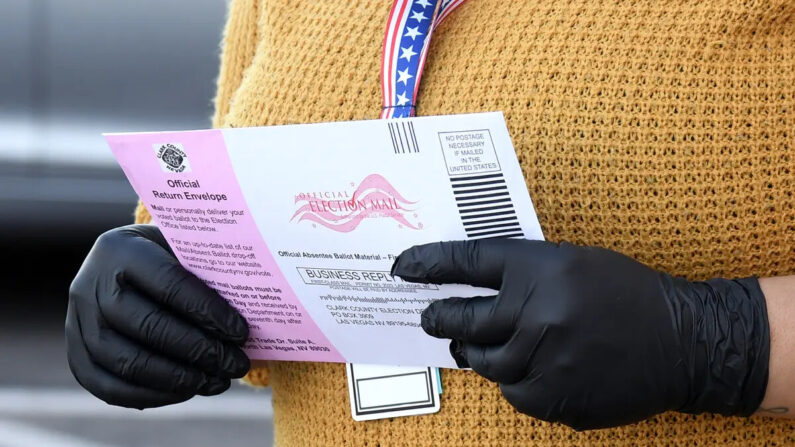 La trabajadora del Departamento Electoral del Condado de Clark, Breanna Silas, acepta boletas en el Departamento Electoral del Condado de Clark, que sirve como punto de entrega de boletas electorales para conducir y caminar en North Las Vegas, Nevada, el 13 de octubre de 2020. (Ethan Miller/Getty Images)