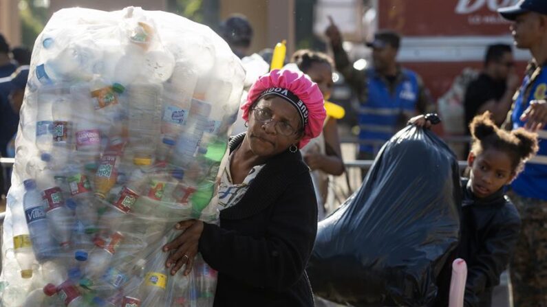 Una mujer espera en la fila para presentar las botellas plásticas recolectadas para la cuarta edición del programa 'Plásticos por Juguetes' el 5 de enero de 2024, en Santo Domingo (República Dominicana). EFE/ Orlando Barría