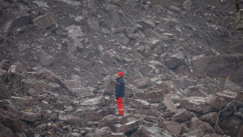 Un miembro del equipo de rescate mira desde los escombros tras el corrimiento de tierras del lunes en la provincia meridional china de Yunnan. EFE/ Mark R. Cristino