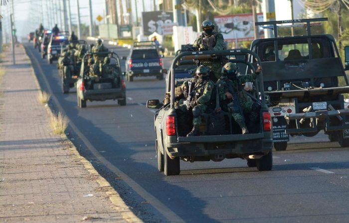 Miembros del Ejército mexicano conducen en una carretera un día después de una operación para detener al hijo de Joaquín "El Chapo" Guzmán, Ovidio Guzmán, en Culiacán, estado de Sinaloa, México, el 6 de enero de 2023. (Juan Carlos Cruz/AFP vía Getty Images)