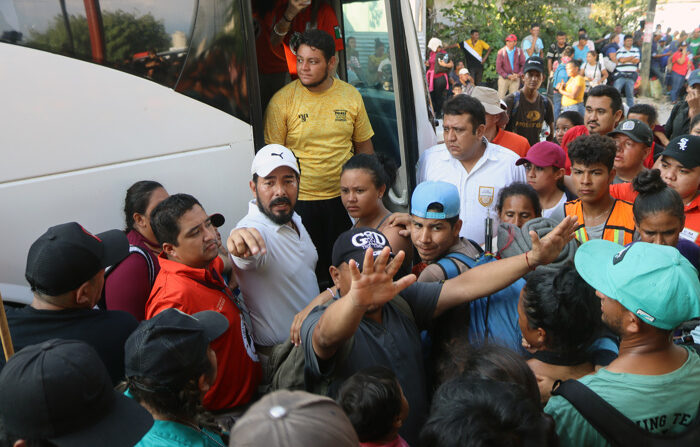 Migrantes abordan un autobús del Instituto Nacional de Migración (INM) tras dar por terminada una caravana rumbo a Estados Unidos hoy, en el municipio de Mapastepec, estado de Chiapas. (EFE/ Juan Manuel Blanco)