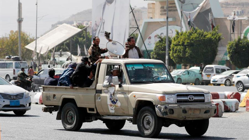 Simpatizantes hutíes viajan en un vehículo pasando junto a una pancarta que representa al máximo líder hutí, Abdul-Malik al-Houthi, en una calle de Saná, Yemen, en una fotografía de archivo. EFE/EPA/Yahya Arhab