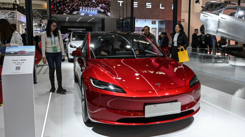 Un grupo de personas prueba el vehículo eléctrico Model 3 de Tesla en su stand durante la China International Supply Chain Expo (CISCE) en Beijing (China) el 1 de diciembre de 2023. (Jade Gao/AFP vía Getty Images)