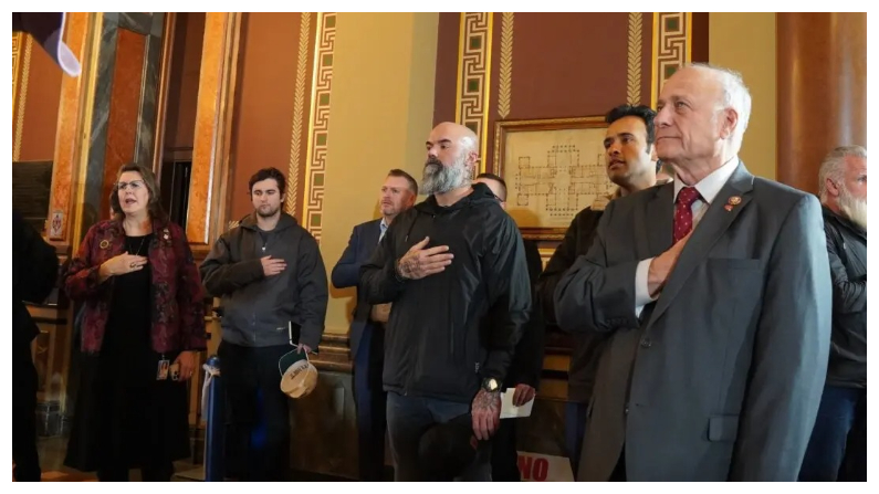Vivek Ramaswamy y Steve King escuchan el Himno Nacional en el Capitolio del Estado de Iowa el 10 de enero del 2024. (Nathan Worcester/The Epoch Times)