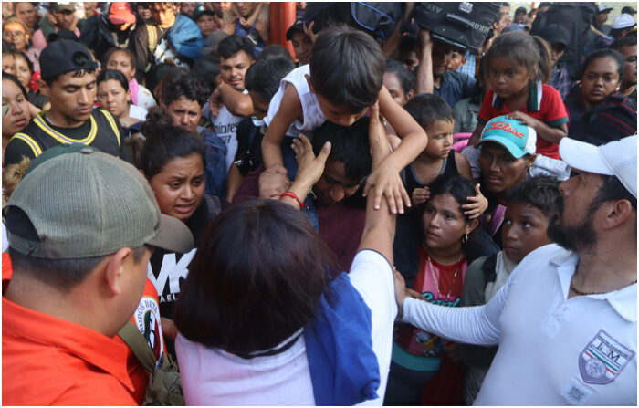 Migrantes se organizan para abordar un autobús del Instituto Nacional de Migración (INM) tras dar por terminada una caravana rumbo a Estados Unidos hoy, en el municipio de Mapastepec,, Chiapas. (EFE/ Juan Manuel Blanco)