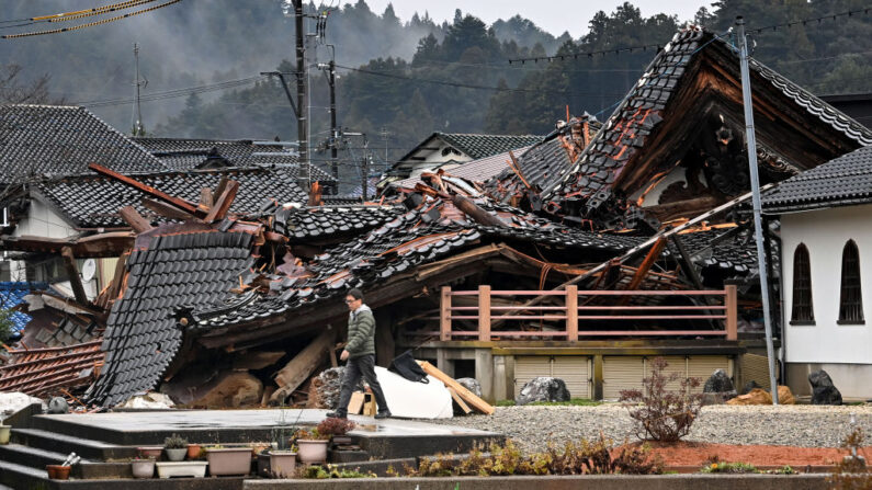 Un hombre pasa junto a una casa derrumbada en la ciudad de Anamizu, prefectura de Ishikawa, el 3 de enero de 2024, después de que un fuerte terremoto de magnitud 7.5 sacudiera la región de Noto (Japón) el día de Año Nuevo. (Kazuhiro Nogi/AFP vía Getty Images)