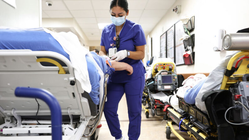 Una técnóloga de laboratorio atiende a un paciente en el Departamento de Emergencias del Centro Médico Providence St. Mary en Apple Valley, California, el 11 de marzo de 2022. (Mario Tama/Getty Images)