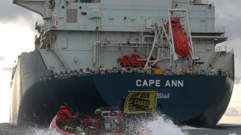 Activistas de Greenpeace Francia con una pancarta en la que se lee "rumbo al caos climático", navegan detrás del buque cisterna Cape Ann LNG de TotalEnergies, anclado frente a la ciudad portuaria de Le Havre, en el norte de Francia, en el Canal de la Mancha, el 18 de septiembre de 2023. (LOU BENOIST/AFP vía Getty Images)