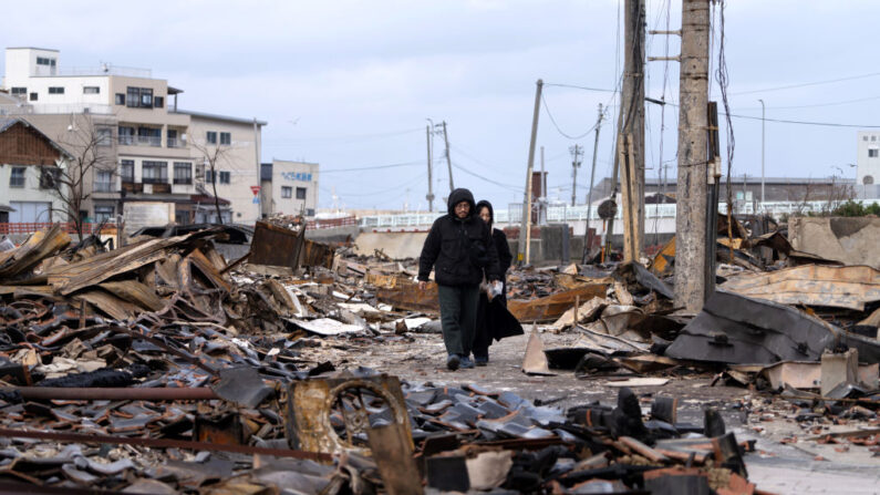 Una pareja camina por la zona de Asaichi Yokocho, o Mercado Matutino de Wajima, tras un incendio provocado por un terremoto el 05 de enero de 2024 en Wajima, Japón. (Tomohiro Ohsumi/Getty Images)