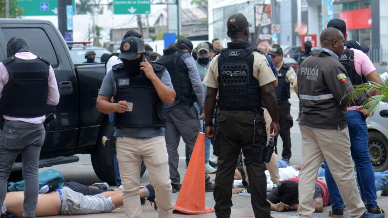 Agentes de policía ecuatorianos custodian a los sospechosos detenidos en el exterior del canal de televisión TC de Ecuador después de que hombres armados no identificados irrumpieran en el estudio de televisión estatal en directo el 9 de enero de 2024, en Guayaquil, Ecuador. (Stringer/AFP vía Getty Images)