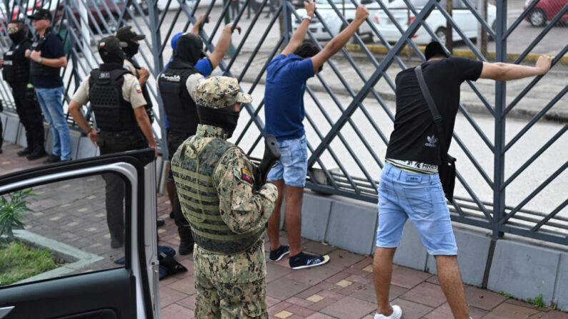 Hombres sospechosos de pertenecer a una banda criminal permanecen detenidos durante una operación conjunta entre la Policía Nacional de Ecuador y miembros de las Fuerzas Armadas para prevenir actos violentos, en Guayaquil, Ecuador, el 15 de enero de 2024. (Yuri Cortez/AFP vía Getty Images)