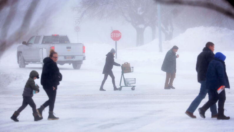 Los compradores caminan a través de la nieve al salir de una tienda de comestibles el 13 de enero de 2024 en West Des Moines, Iowa (EE.UU.). (Scott Olson/Getty Images)