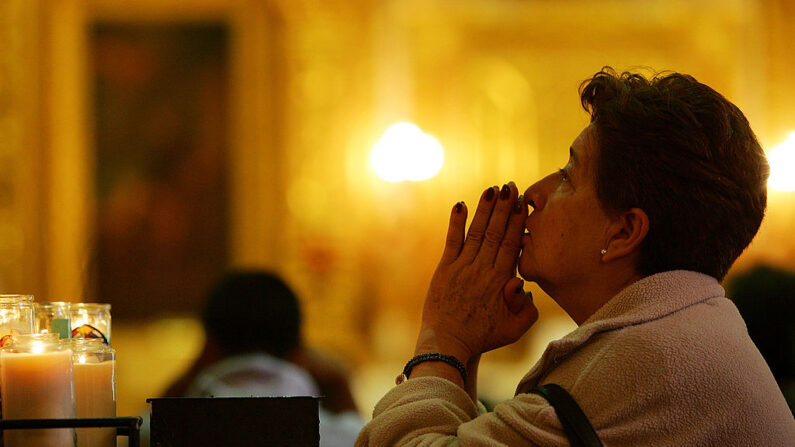 Una mujer reza en la Iglesia Católica Nuestra Señora Reina de Los Ángeles, fundada en 1781 y a la que actualmente asisten principalmente inmigrantes latinos, el 5 de abril de 2007 en Los Ángeles, California. (David McNew/Getty Images)