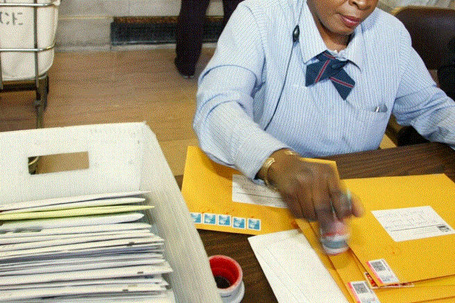 En una fotografía de archivo, se ve a un trabajador postal colocando sobres con sellos destinados al Servicio de Impuestos Internos (IRS). (Monika Graff/Getty Images)