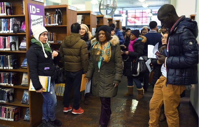 La gente espera por sus tarjetas de identificación municipal de la ciudad de Nueva York 14 de enero 2015, en la sucursal de Flushing de la Biblioteca Pública de Queens. (DON EMMERT/AFP via Getty Images)