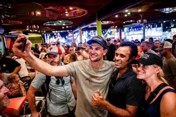 El candidato presidencial republicano, el empresario Vivek Ramaswamy (C), se hace un selfie con sus seguidores en el Jalapeno Pete's Bar de la Feria Estatal de Iowa, en Des Moines, Iowa, el 11 de agosto del 2023. (Brandon Bell/Getty Images)