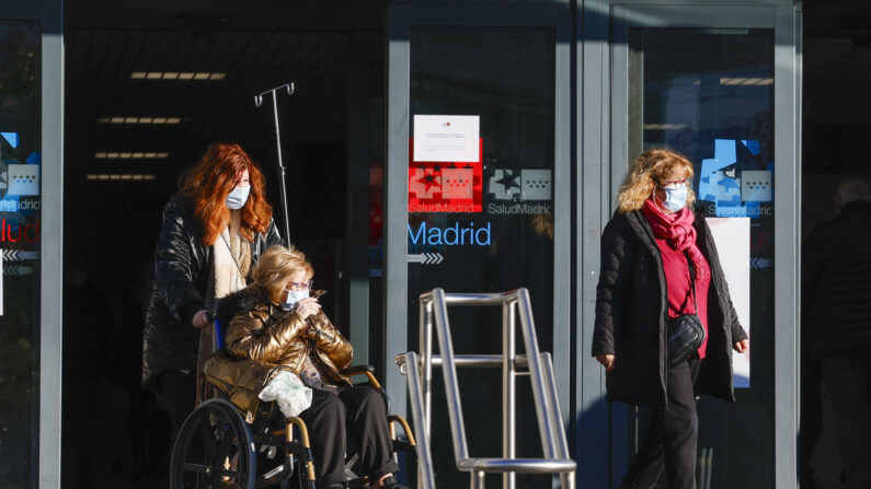 Varias personas con la mascarilla, salen del Hospital de La Paz de Madrid, este jueves. (EFE/ JJ.Guillén)