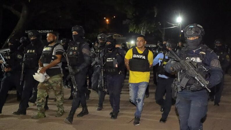 Agentes de Policía trasladan a Jorge Alberto Viera (c), uno de los tres hondureños que Estados Unidos ha solicitado en extradición por el delito de tráfico de drogas, a las instalaciones de Fuerzas Especiales de La Policía Nacional en Tegucigalpa (Honduras). EFE/ Gustavo Amador