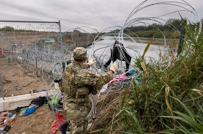Un soldado de la Guardia Nacional de Texas instala más alambre de púas en la frontera entre Estados Unidos y México, en Eagle Pass, Texas, el 20 de diciembre de 2023. (John Moore/Getty Images)