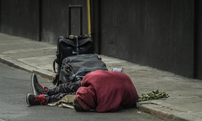 Un hombre sin hogar yace en la calle en San Francisco el 23 de febrero de 2023. (John Fredricks/The Epoch Times)