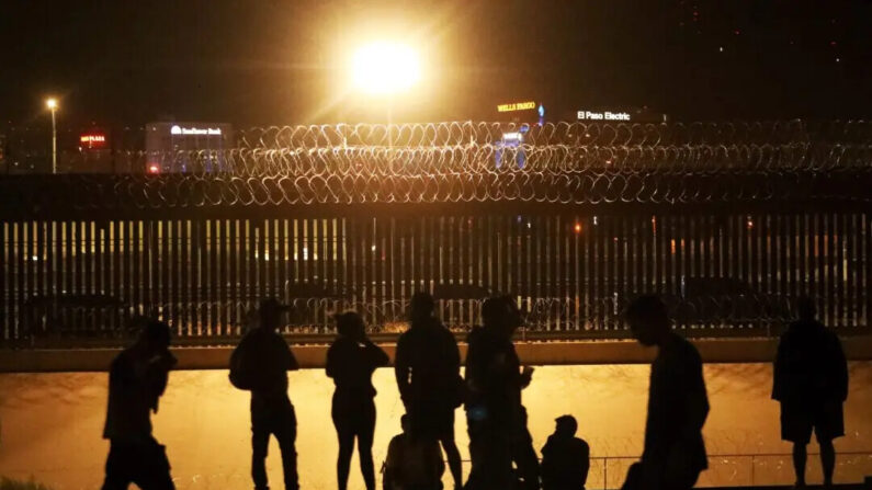 Inmigrantes esperan a ser recibidos a través de un puente ferroviario en la frontera entre El Paso, Texas, y Ciudad Juárez, estado de Chihuahua, México, el 7 de agosto de 2023. (Herika Martinez/AFP vía Getty Images)