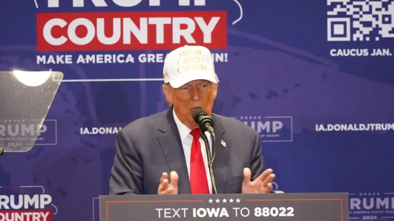 El expresidente Donald Trump, con una gorra blanca de "capitán del caucus de Trump", insta a sus seguidores a votar por él en la noche del caucus durante unas declaraciones en el Simpson College, Indianola, Iowa, el 14 de enero de 2024. (Gary Du/NTD)