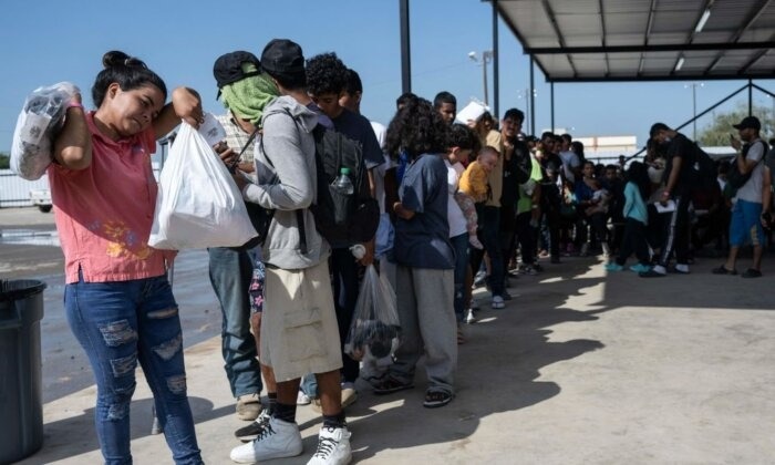 Inmigrantes ilegales hacen cola mientras esperan un autobús a Chicago en el complejo de la ONG Mission Border Hope para transportarlos fuera de Eagle Pass, Texas, el 26 de septiembre de 2023. (Andrew Caballero-Reynolds/AFP vía Getty Images)